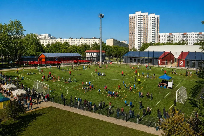 Открытое поле Юрловского с высоты: игровые станции, команды и зрители вдоль ограждения