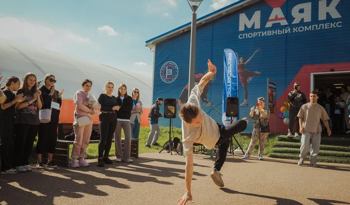 Танцор брейкданса выступает на площадке у «Маяка», гости феста аплодируют